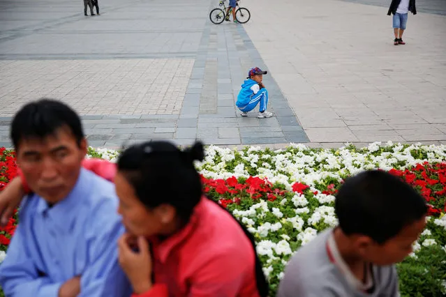 People pass time at Genghis Square in central Ulaanbaatar, Mongolia, July 13, 2016. (Photo by Damir Sagolj/Reuters)