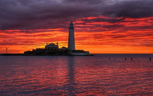 A fire coloured sky above St Mary's Lighthouse in Whitley bay on the North East coast of England just before sunrise on Friday, July 15, 2022. (Photo by Owen Humphreys/PA Images via Getty Images)