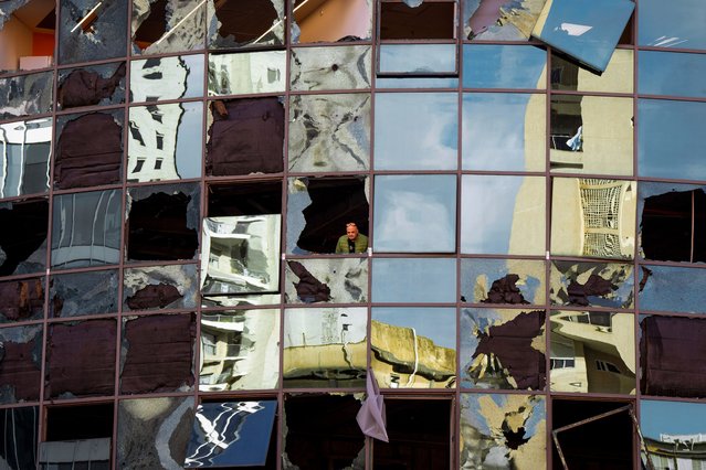 A man looks from a damaged building a day after it was hit by a rocket fired from Lebanon, in Ramat Gan, central Israel, Tuesday, November 19, 2024. (Photo by Oded Balilty/AP Photo)