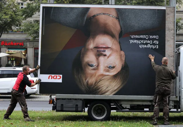 Workers remove an election campaign billboard showing Christian Democratic Union CDU party leader and German Chancellor Angela Merkel, the day after the general election (Bundestagswahl) in Berlin, Germany September 25, 2017. (Photo by Christian Mang/Reuters)