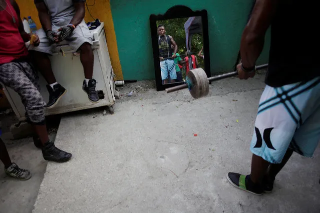 A man is reflected in a mirror as he lifts weight at a public park in Port-au-Prince, Haiti July 28, 2016. (Photo by Andres Martinez Casares/Reuters)