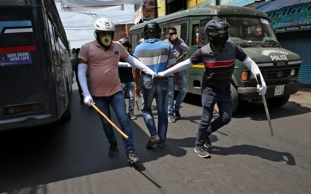 Plainclothes policemen detain a man for defying the lockdown imposed by the government to slow the spreading of coronavirus disease (COVID-19) at Howrah on the outskirts of Kolkata, India, April 19, 2020. (Photo by Rupak De Chowdhuri/Reuters)