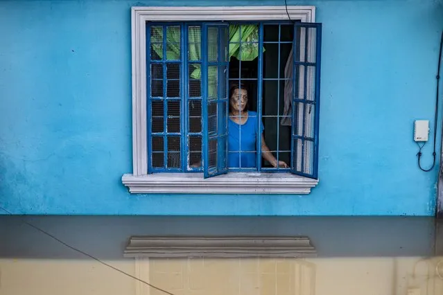 A woman looks out from her home, which was flooded by Super Typhoon Noru on September 26, 2022 in San Ildefonso, Bulacan province, Philippines. Super Typhoon Noru made landfall in the Philippines overnight, causing widespread flooding and leaving at least five dead. High winds and heavy rains have flattened villages and have increased the threat of landslides. (Photo by Ezra Acayan/Getty Images)