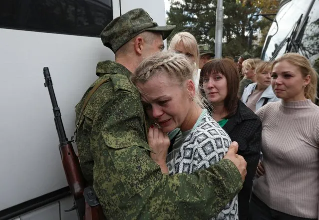 A woman says goodbye to a reservist drafted during the partial mobilisation, before his departure for a military base, in Sevastopol, Crimea on September 27, 2022. (Photo by Alexey Pavlishak/Reuters)