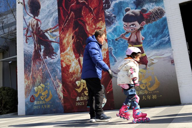 A child skates past promotional posters for the Chinese movie “Nezha 2” outside the office of a film production company in Beijing, China, on February 19, 2025. (Photo by Florence Lo/Reuters)