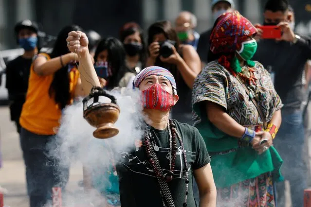 Mayan indigenous people take part in a ceremony in memory of Domingo Choc, a 56-year-old practitioner of traditional Maya medicine who was set ablaze by a mob accusing him of witchcraft, at the Parque Central in Guatemala City, Guatemala on June 10, 2020. (Photo by Luis Echeverria/Reuters)