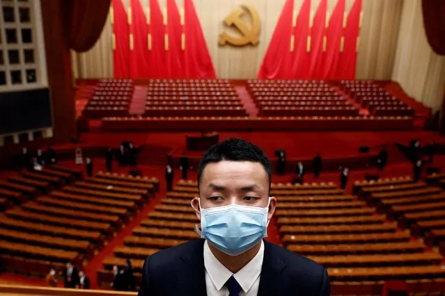 A security personnel, wearing a face mask following the coronavirus disease (COVID-19) outbreak, keeps watch at the end of the opening ceremony of the 20th National Congress of the Communist Party of China, at the Great Hall of the People in Beijing, China on October 16, 2022. (Photo by Thomas Peter/Reuters)