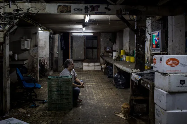 A man watches the Olympic games on his TV in the basement of a shop on August 15, 2016 in Rio de Janeiro, Brazil. Around 1.4 million residents, or approximately 22 percent of Rio's population, reside in favelas which often lack proper sanitation, health care, education and security, for many of these residents watching the Olympic games on TV is their only access to the event. (Photo by Chris McGrath/Getty Images)