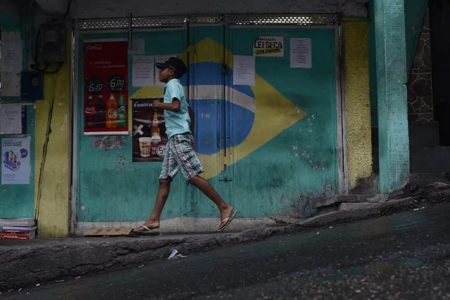 A boy runs a hill in the favela Vidigal before the start of the men's gold medal soccer match between Brazil and Germany during Rio 2016 on Saturday, August 20, 2016. Brazil won the gold medal in a 5-4 shootout. (Photo by Aaron Ontiveroz/The Denver Post)