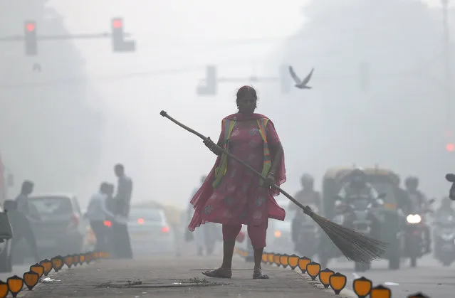 A street cleaner works in heavy smog in Delhi, India, November 10, 2017. (Photo by Cathal McNaughton/Reuters)