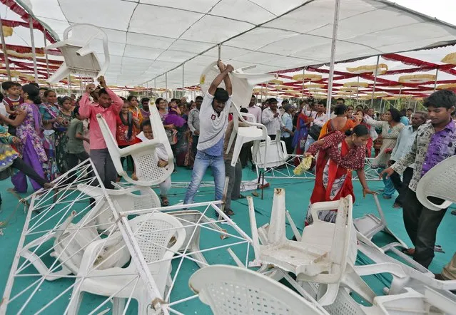 People throw chairs installed at an event celebrating Indian Prime Minister Narendra Modi's 65th birthday in Ahmedabad, India, September 17, 2015. Angry parents who wanted to take selfies with their daughters got violent after organisers failed to start an event planned in Modi's home state of Gujarat. (Photo by Amit Dave/Reuters)