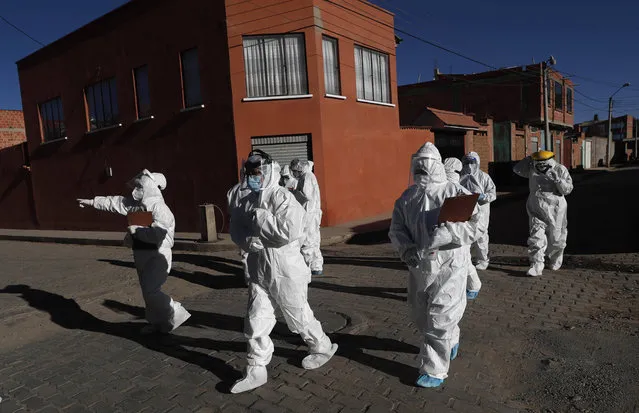 Dressed in full protective gear, doctors span out in a house-to-house new coronavirus testing campaign in the Villa Jaime Paz Zamora neighborhood of El Alto, Bolivia, Saturday, July 4, 2020. (Photo by Juan Karita/AP Photo)