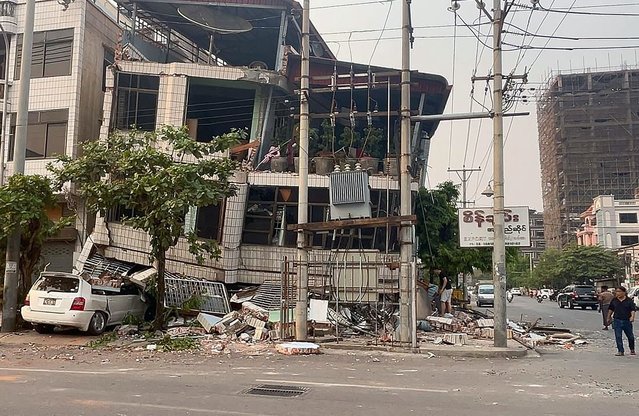 A car is crushed under a collapsed building in Mandalay on March 28, 2025, after an earthquake in central Myanmar. (Photo by AFP Photo/Stringer)
