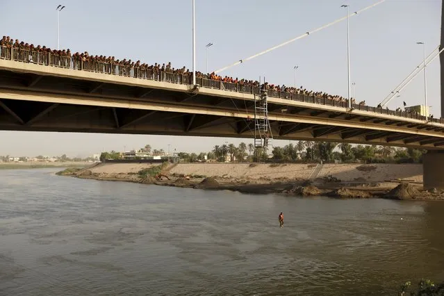 An Iraqi army cadet performs “the leap of faith” from a bridge in Baghdad, September 22, 2015. (Photo by Ahmed Saad/Reuters)