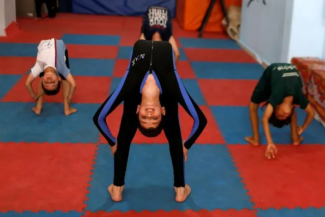 Palestinian boys perform during a yoga and flexibility class on International Yoga Day in Gaza City on June 21, 2020. (Photo by Mohammed Salem/Reuters)