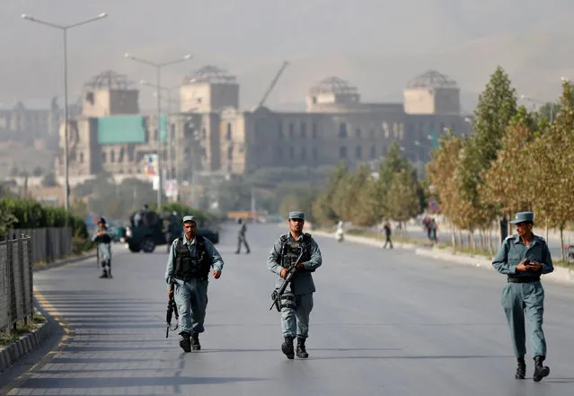 Afghan policemen walk after an attack at the American University of Afghanistan in Kabul, Afghanistan August 25, 2016. (Photo by Mohammad Ismail/Reuters)