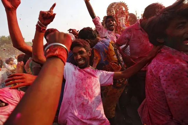 Devotees dance as idols of the Hindu elephant god Ganesh, the deity of prosperity, are immersed into the polluted waters of the river Yamuna on the last day of the Ganesh Chaturthi festival, in New Delhi, India, September 27, 2015. (Photo by Adnan Abidi/Reuters)