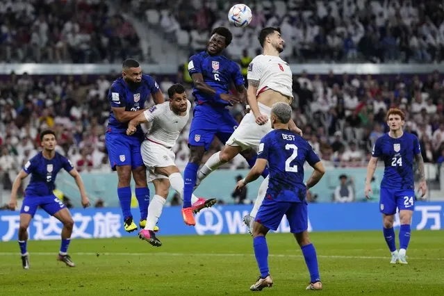 Players fight for a header during the World Cup group B soccer match between Iran and the United States at the Al Thumama Stadium in Doha, Qatar, Tuesday, November 29, 2022. (Photo by Manu Fernandez/AP Photo)