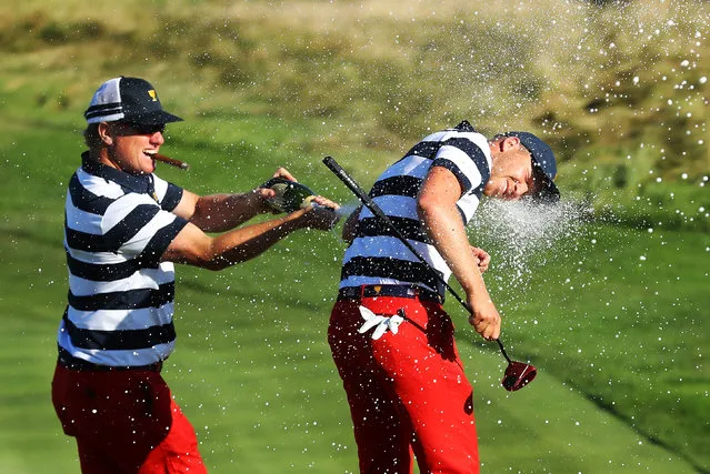 Charlie Hoffman sprays Daniel Berger of the U.S. Team with champagne after Berger defeated Si Woo Kim of South Korea and the International Team on the 17th hole 2&1 to give the U.S. Team the clinching point to win the Presidents Cup during Sunday singles matches at Liberty National Golf Club on October 1, 2017 in Jersey City, New Jersey. (Photo by Sam Greenwood/Getty Images)