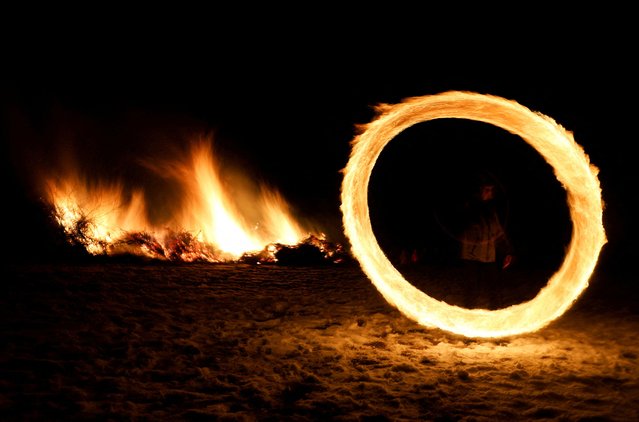 A child spins a ring of fire during rituals in celebration of Mesni Zagovezni, the second Sunday before Great Lent, in Lozen, Bulgaria, on February 23, 2025. (Photo by Spasiyana Sergieva/Reuters)