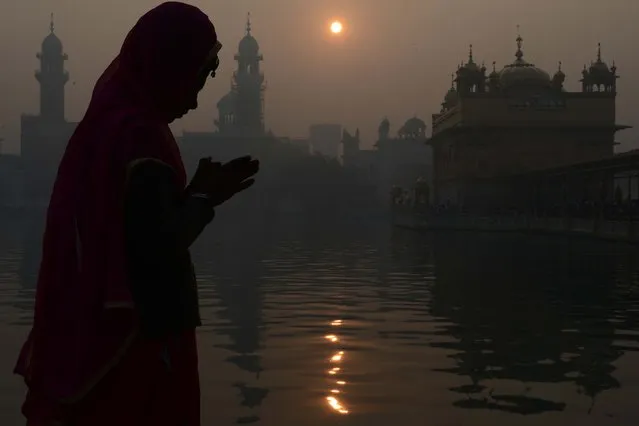 An Indian Sikh devotee pays respect in the early morning on the occasion of the New Year 2018 at the Golden temple in Amritsar on January 1, 2018. (Photo by Narinder Nanu/AFP Photo)