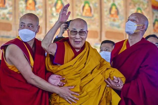 Tibetan spiritual leader Dalai Lama waves during his first day of teaching session at the Kalachakra Ground in Bodhgaya on December 29, 2022. (Photo by Sanjay Kumar/AFP Photo)