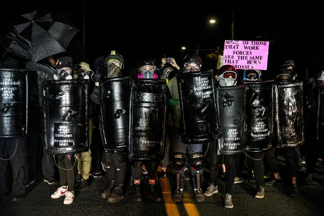 Protestors wearing gas masks and carrying homemade take part in the 100th day and night of protests against racism and police brutality in Portland, Oregon, on September 5, 2020. Police arrested dozens of people and used tear gas against hundreds of demonstrators in Portland late on September 5 as the western US city marked 100 days since Black Lives Matter protests erupted against racism and police brutality. Protests in major US cities erupted after the death of African American George Floyd in May 2020 at the hands of a white police officer in Minneapolis. (Photo by Allison Dinner/AFP Photo)
