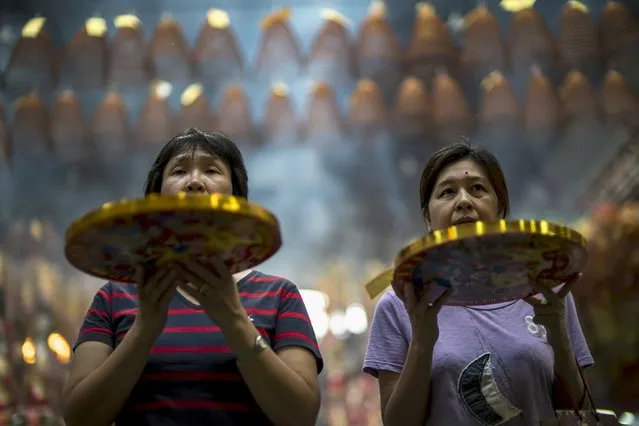 People pray at a shrine in Chinatown, Bangkok, Thailand, October 14, 2015. (Photo by Athit Perawongmetha/Reuters)