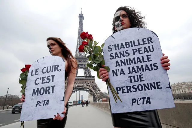 Activists from the People for the Ethical Treatment of Animals (PETA) demonstrate with slogans in protest of the designers continued use of leather in front of the Eiffel Tower during the Paris Fashion Week, in Paris, France, February 27, 2018. Placards in the shape of tombstones read, “To dress without animal skin never killed anyone” (R) and “Leather is Dead”. (Photo by Benoit Tessier/Reuters)