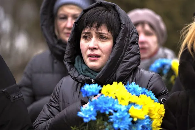 A woman cries during a memorial service to mark the one-year anniversary of the start of the Russia Ukraine war, in a cemetery in Bucha, Ukraine, Friday, February 24, 2023. (Photo by Emilio Morenatti/AP Photo)