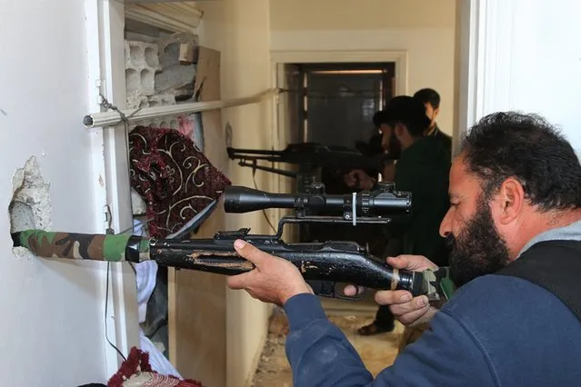 Rebel fighters aim their weapons inside a building near the frontline against forces loyal to Syria's President Bashar al-Assad in al-Manshiyeh neighborhood in Deraa December 7, 2014.  Picture taken December 7, 2014. (Photo by Wsam Almokdad/Reuters)