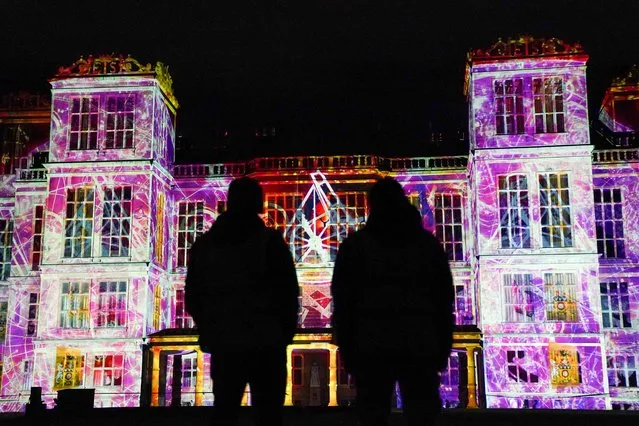 People observe projections including Bess of Hardwick and Queen Elizabeth I lighting up the façade of Hardwick Hall, near Chesterfield in Derbyshire, as part of the National Trust's “Shine A Light” celebration of the county's history and heritage on Thursday, February 16, 2023. (Photo by Jacob King/PA Images via Getty Images)