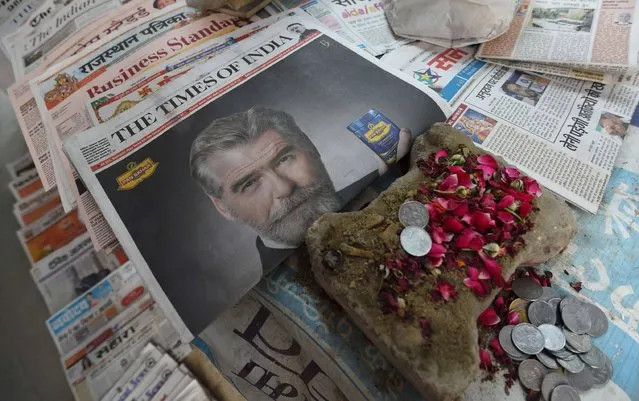 A newspaper with a front page advertisment of former 007 star Pierce Brosnan endorsing an Indian mouth freshener, is seen on the streets of New Delhi on October 7, 2016. Former 007 star Pierce Brosnan sparked ridicule on social media October 7, 2016 by starring in a new James Bond-style spoof commercial for an Indian mouth freshener that left fans shaken and stirred. (Photo by Dominique Faget/AFP Photo)
