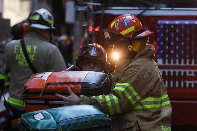 Firefighters check their equipment at the site of a collapsed parking garage in the Manhattan borough of New York City, U.S., April 18, 2023. (Photo by Brendan McDermid/Reuters)