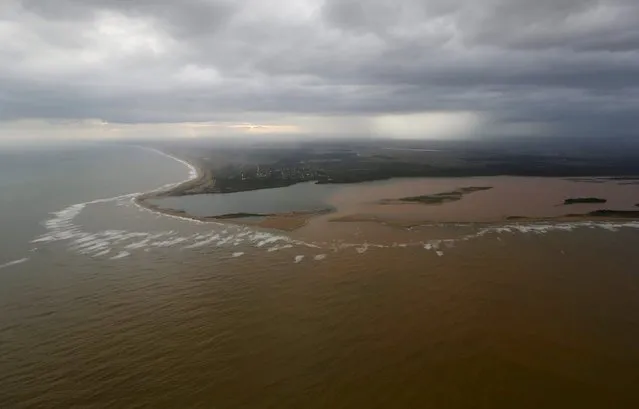 An aerial view of the mouth of Rio Doce (Doce River), which was flooded with mud after a dam owned by Vale SA and BHP Billiton Ltd burst, is seen as the river joins the sea on the coast of Espirito Santo, in Regencia Village, Brazil, November 21, 2015. (Photo by Ricardo Moraes/Reuters)