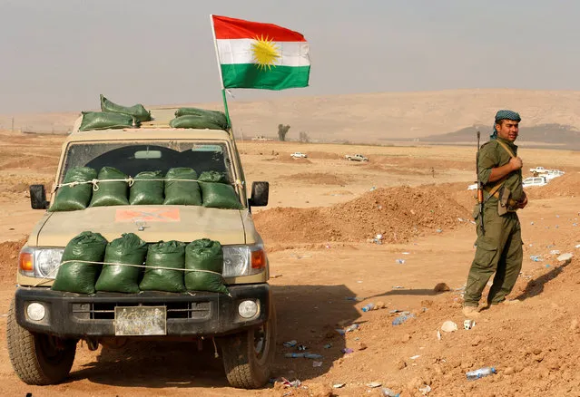 A Kurdish peshmerga fighter takes up a position as they clear Fadiliya village in Nawaran, north of Mosul, as part of their offensive to drive Islamic State from Mosul, Iraq, October 26, 2016. (Photo by Ahmed Jadallah/Reuters)