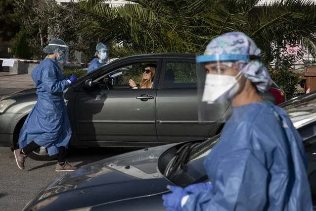 Medical personnel conduct COVID-19 rapid tests of teachers and staff of primary schools at a drive-through testing site, at Glyfada suburb, south of Athens, Sunday, January 10, 2021. As general lockdown measures extended for a week to Jan.18, Greek government announced the reopening of primary schools and kindergatens as of Monday. (Photo by Yorgos Karahalis/AP Photo)