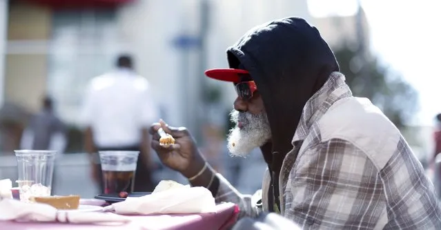 A man eats an early Thanksgiving meal served to the homeless at the Los Angeles Mission in Los Angeles, California, November 25, 2015. (Photo by Mario Anzuoni/Reuters)