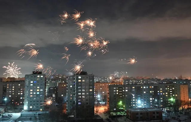 Fireworks explode over apartment blocks during New Year's Day celebrations in Omsk, Russia on January 1, 2021. (Photo by Alexey Malgavko/Reuters)