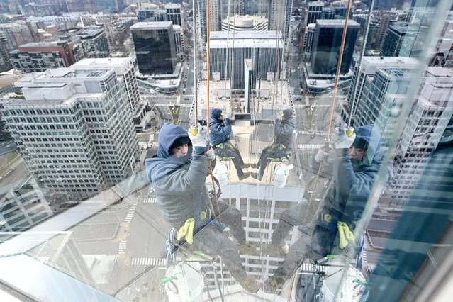 Window washers repel as they work on cleaning the glass outside the View of DC observation deck in the Rosslyn neighborhood on Friday January 27, 2023 in Arlington, VA. (Photo by Matt McClain/The Washington Post)
