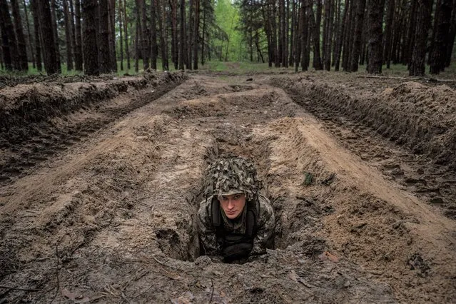 A Ukrainian serviceman lies in a trench during a military exercise in the Kharkiv region on May 1, 2023, amid the Russian invasion of Ukraine. (Photo by Dimitar Dilkoff/AFP Photo)