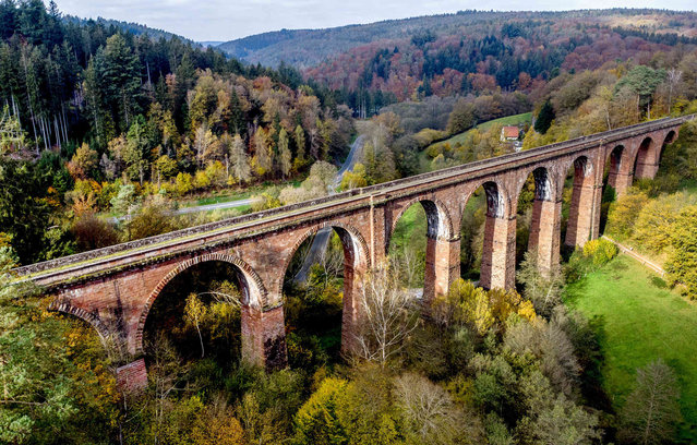 The 250 meter long Himbaechel viaduct that was built in 1881 is surrounded by the colourful trees of the Odenwald region in Erbach, Germany, Sunday, November 3, 2024. (Photo by Michael Probst/AP Photo)