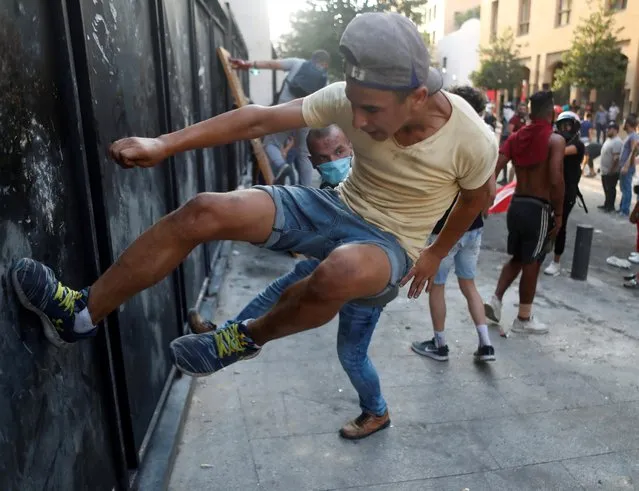 A demonstrator tries to break a barrier during a protest in Beirut, Lebanon on August 11, 2020. (Photo by Goran Tomasevic/Reuters)