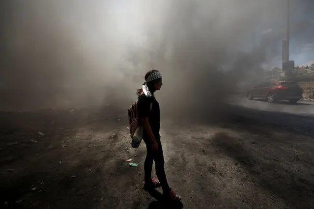 A Palestinian girl stands amongst smoke during clashes with Israeli troops at a protest near the Jewish settlement of Beit El, near Ramallah, in the occupied West Bank June 29, 2018. (Photo by Mohamad Torokman/Reuters)