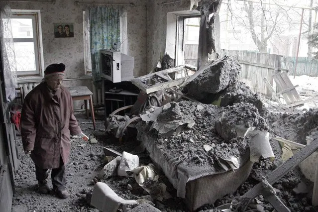 A woman surveys damage done to a house, which according to locals was recently damaged by shelling, in the suburbs of Donetsk January 30, 2015. (Photo by Alexander Ermochenko/Reuters)