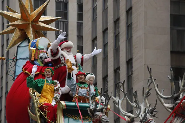 Santa Claus waves to the crowd during the 90 th annual Macy' s Thanksgiving Day Parade on November 24, 2016 in New York Dump trucks filled with sand are being used to block streets durin the parade. (Photo by Kena Betancur/AFP Photo)