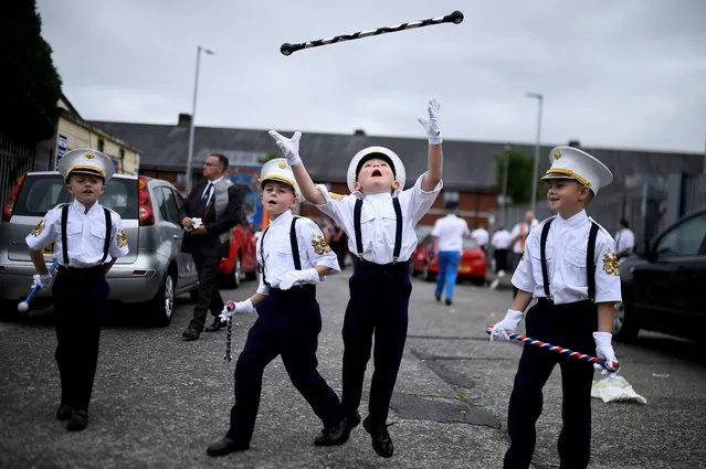 Young members of Loyalist Orders throw a baton in the air as they participate in Twelfth of July celebrations in Belfast, Northern Ireland July 12, 2018. (Photo by Clodagh Kilcoyne/Reuters)