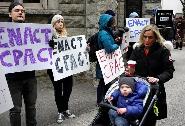 A woman pushing a child in a stroller reacts as she walks past demonstrators holding signs as protesters try to disrupt Black Friday shopping in Chicago, Illinois, November 25, 2016. The protests are in reaction to the recent fatal police shootings of Joshua Beal and Kajuan Raye, who were recently killed by Chicago police officers in separate incidents in November. (Photo by Joshua Lott/Reuters)