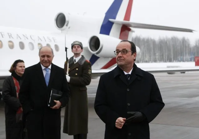 France's President Francois Hollande (R) and Foreign Minister Laurent Fabius (2nd L) take part in a welcoming ceremony upon their arrival at an airport near Minsk, February 11, 2015. (Photo by Valentyn Ogirenko/Reuters)