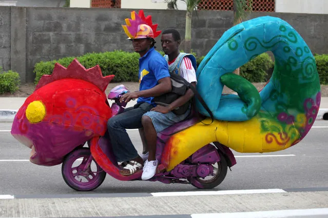 People riding a motorcycle attend a street carnival at Tafawa Balewa square in Nigeria's commercial capital Lagos April 30, 2011. The carnival was organised by the Lagos metropolitan government as part of Easter celebrations. (Photo by Akintunde Akinleye/Reuters)